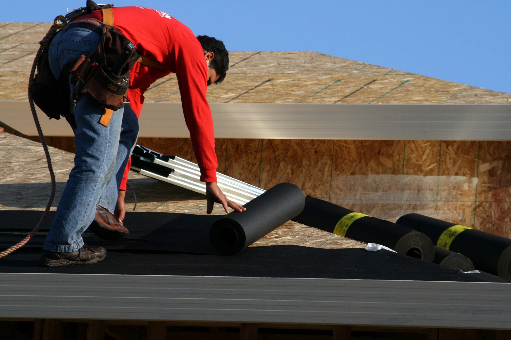 Man on roof laying underlayment